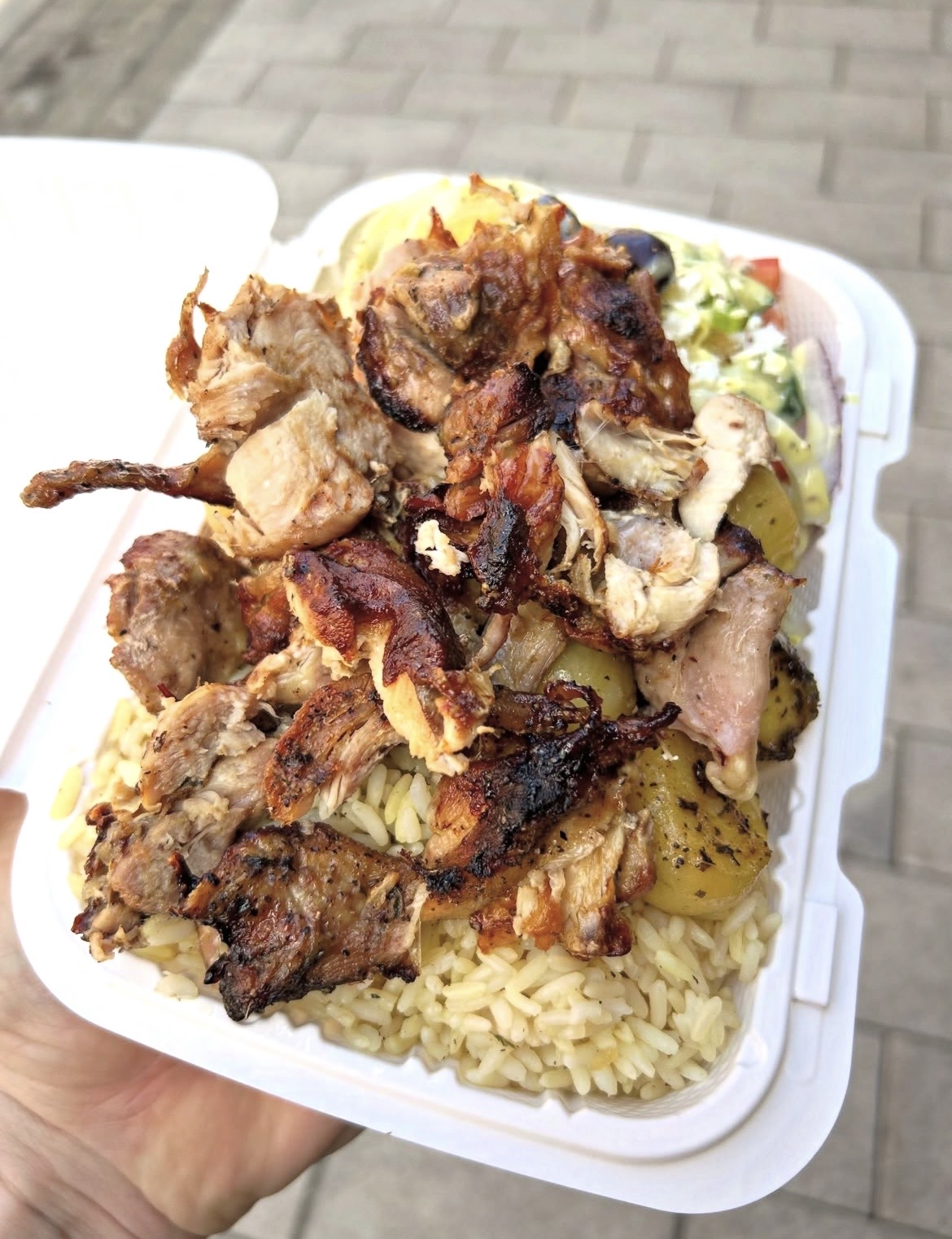 Roasted chicken dinner over rice with potatoes and salad